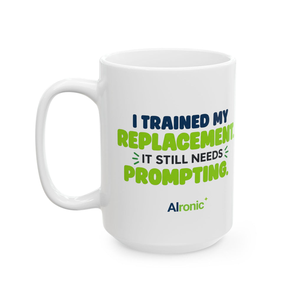 White ceramic mug featuring "I trained my replacement. It still needs prompting." AIronic design, tall front-left view