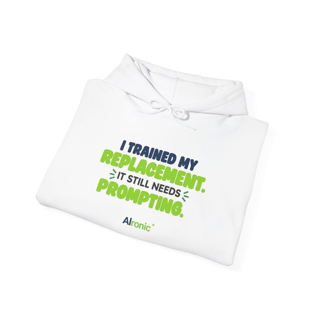 White hoodie featuring "I trained my replacement. It still needs prompting." AIronic design, folded detail view