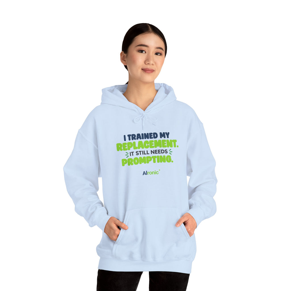 Light Blue hoodie featuring "I trained my replacement. It still needs prompting." AIronic design, modeled front view