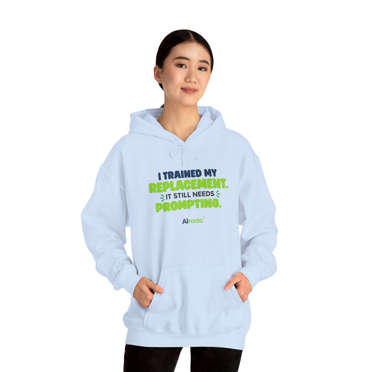 Light Blue hoodie featuring "I trained my replacement. It still needs prompting." AIronic design, modeled front view