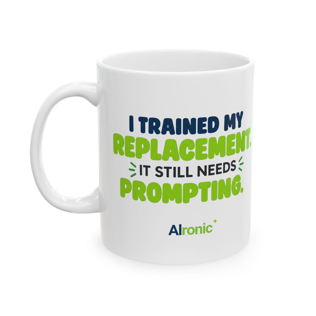 White ceramic mug featuring "I trained my replacement. It still needs prompting." AIronic design, front-left view