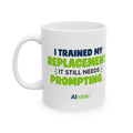 White ceramic mug featuring "I trained my replacement. It still needs prompting." AIronic design, front-left view