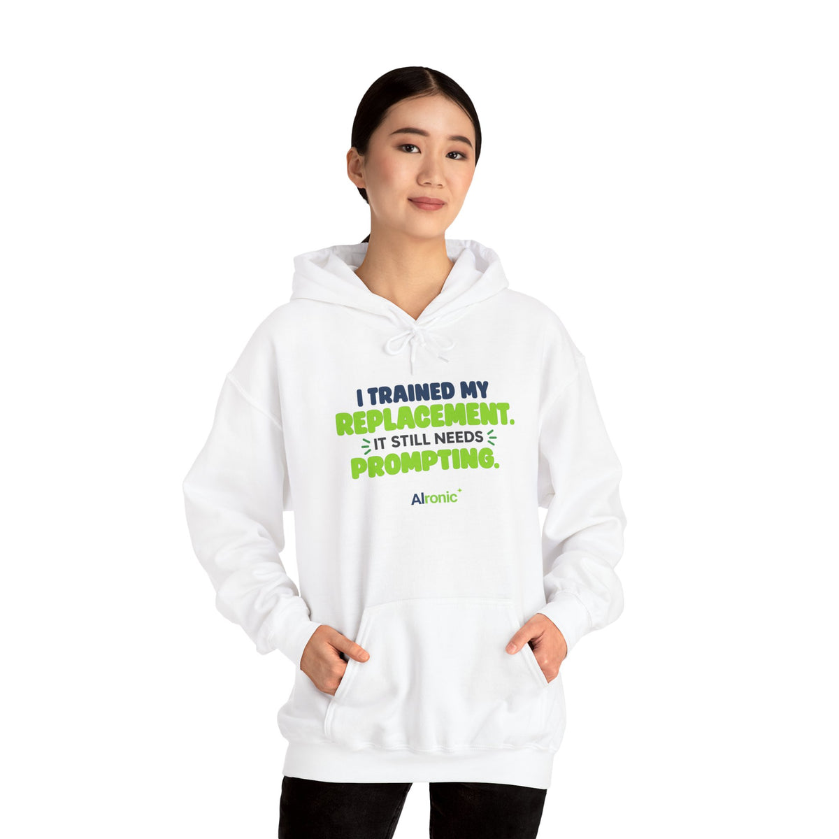 White hoodie featuring "I trained my replacement. It still needs prompting." AIronic design, modeled front view