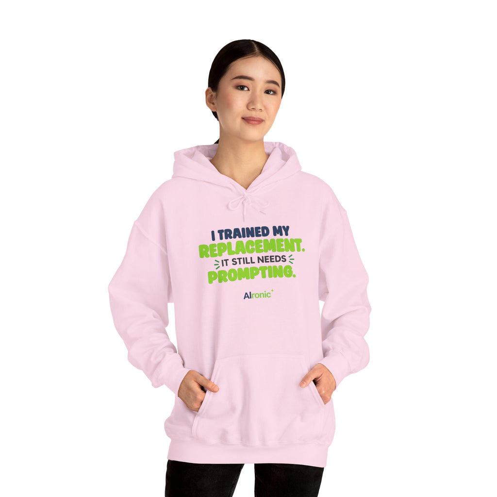 Light Pink hoodie featuring "I trained my replacement. It still needs prompting." AIronic design, modeled front view